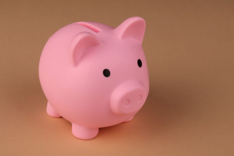 Pușculiță ceramică lângă o periuță de dinți, simbol al economisirii pentru un tratament dentar